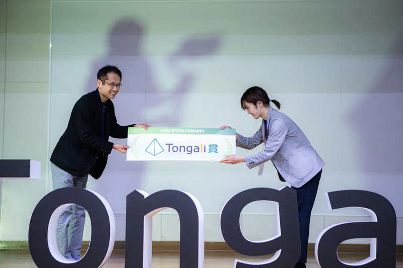 Tongali IDEA PITCH CONTESTの授与式でTongali賞のパネルを受け取る様子